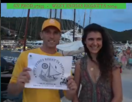 Deux membres de l’organisation présentent l’affiche de la West Indies Regatta sur le quai