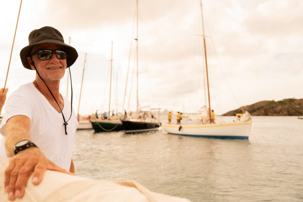 Alexis Andrews à bord, devant la flottille de sloops traditionnels au mouillage
