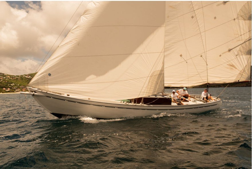 Summer Cloud sous grand-voile et génois pendant la West Indies Regatta, Bryn son nouveau propriétaire à la barre, la côte de Saint-Barthélemy en arrière-plan