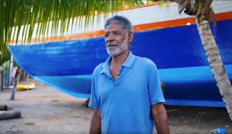 Anthony Nero McLawrence devant la coque bleue de Reality 2 à Windward