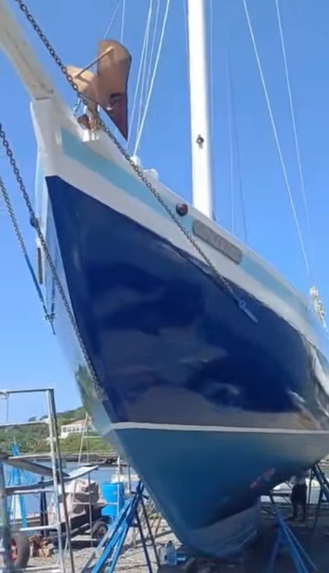 La coque bleue du sloop Beauty of Petite Martinique posée sur bers au chantier
