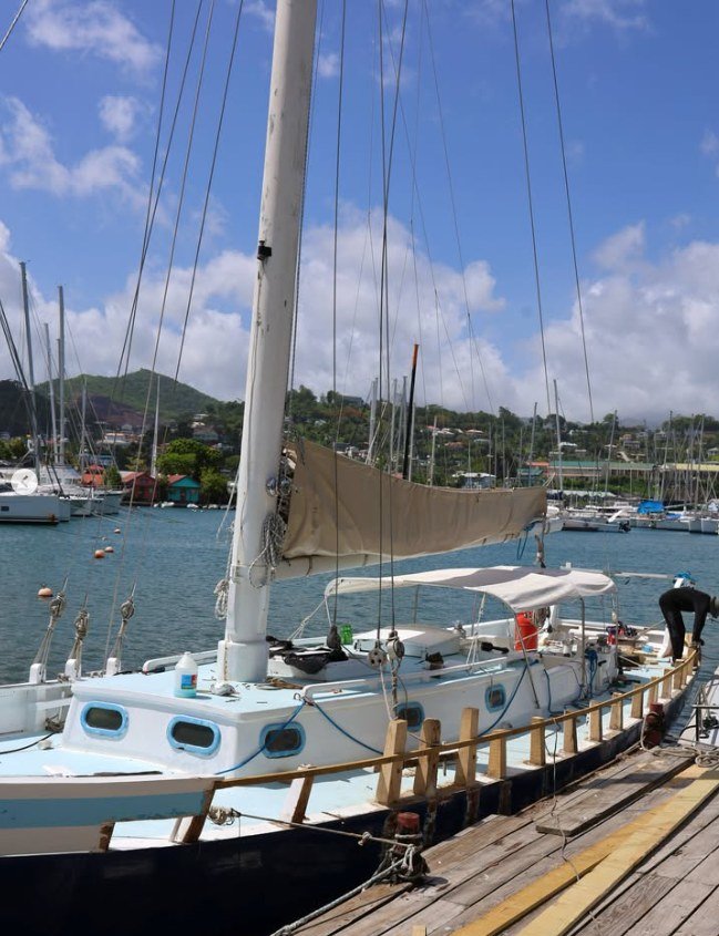 Le sloop Beauty of Petite Martinique amarré à un ponton, grand-voile ferlée sur la bôme