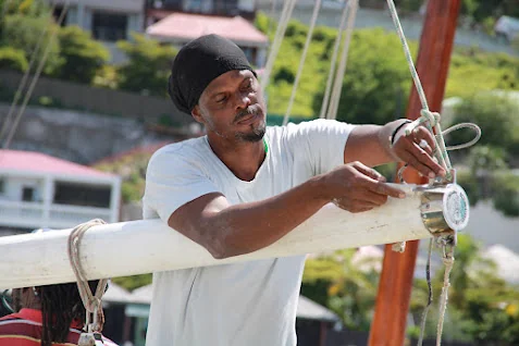 Callistus Enoe règle un cordage sur la bôme de Free in St Barth