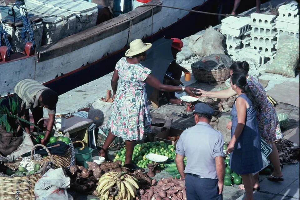 Vente de légumes et de fruits posés sur le quai de Gustavia, devant les sloops accostés