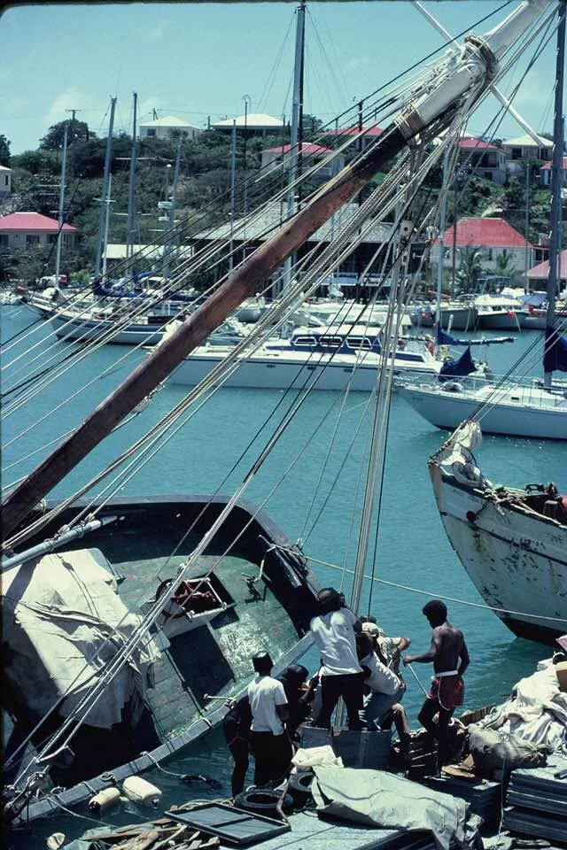 Un sloop couché sur le flanc contre le quai de Gustavia, mât et gréement en travers