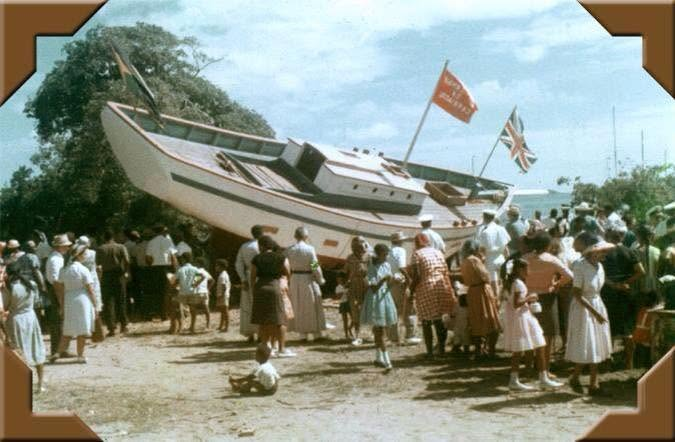 La mise à l’eau du sloop Mermaid of Carriacou le 21 janvier 1968 à Windward : la coque blanche penchée sur la plage, pavois hissés, tout le village massé autour du bateau