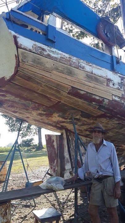 Bordés de bois clair fraîchement posés sur la coque du Mermaid, le capitaine appuyé à l’établi sous le bateau